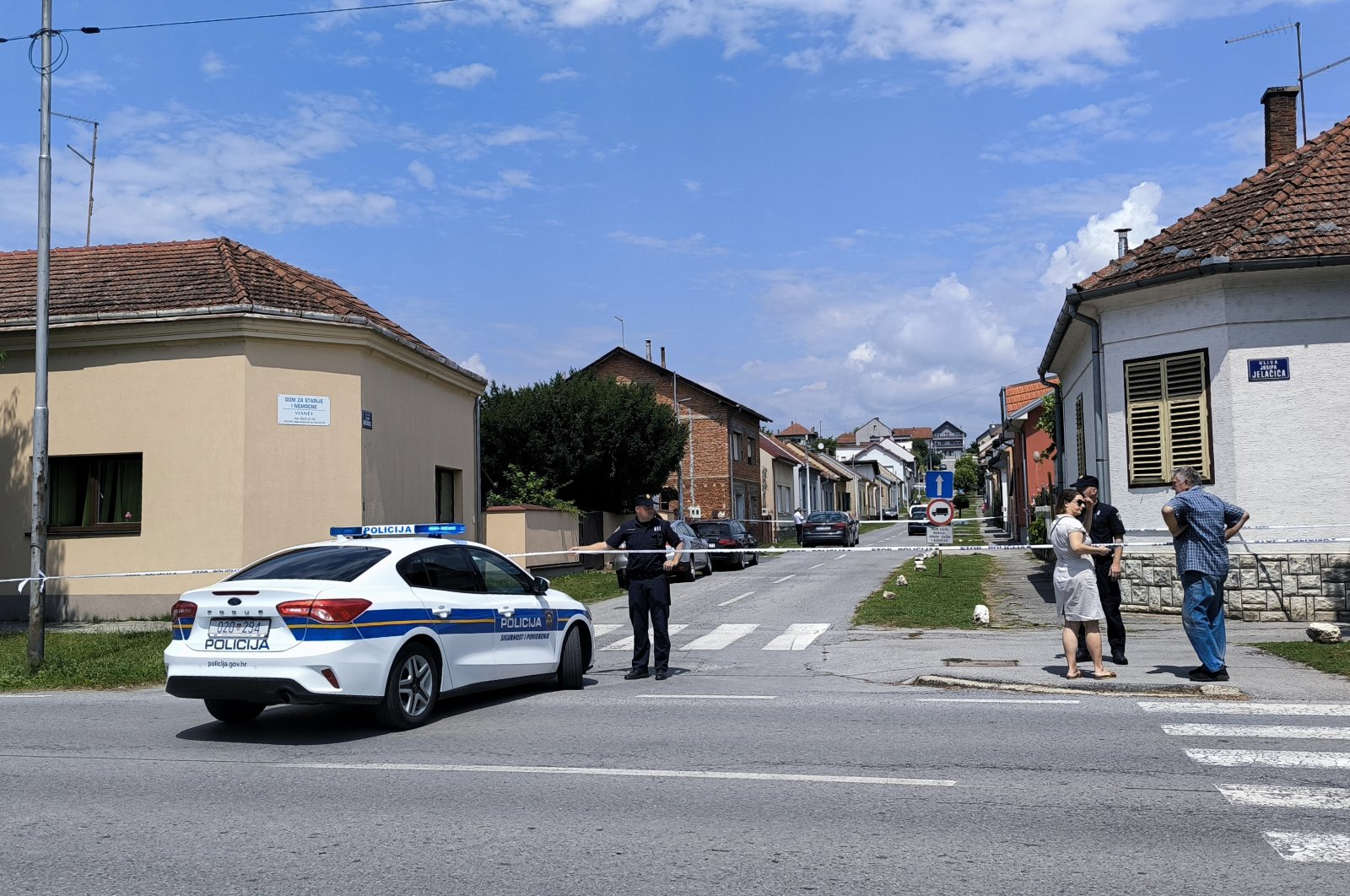 A police officer stands guard behind a police tape next to a retirement home where at least five people were killed in a shooting in Daruvar, Croatia, July 22, 2024. (AFP Photo)