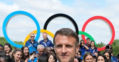French President Emmanuel Macron looks on with the Olympic rings displayed behind him, leaves after posing with French athletes during a visit at the Olympic Village head of the opening ceremony of the Paris 2024 Olympic and Paralympic Games, in Saint-Denis, Paris, France, July 22, 2024. (AFP Photo)