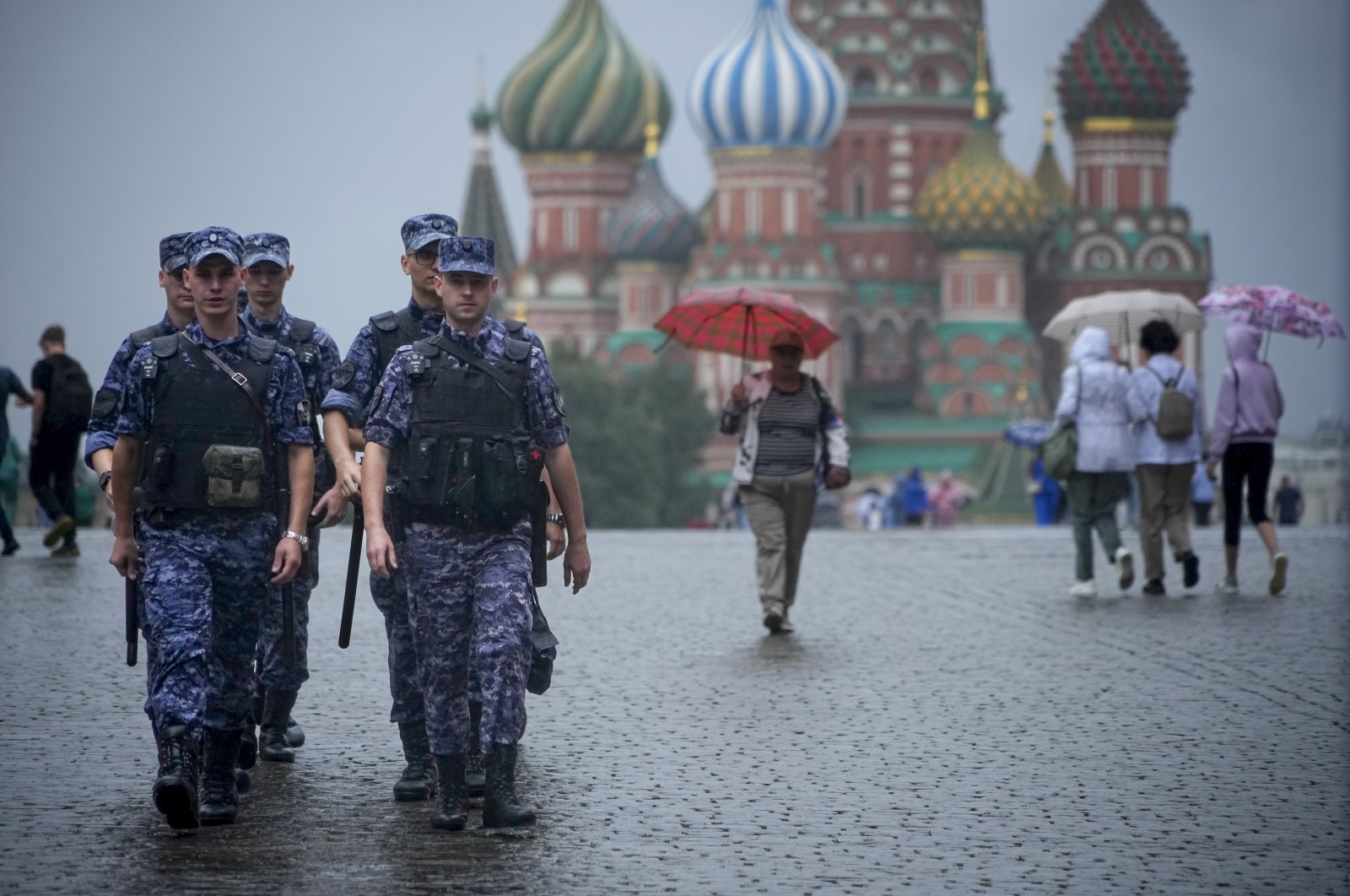 A group of Rosgvardia (National Guard) servicemen walk under the rain through Red Square in Moscow, Russia, July 22, 2024. (AP Photo)