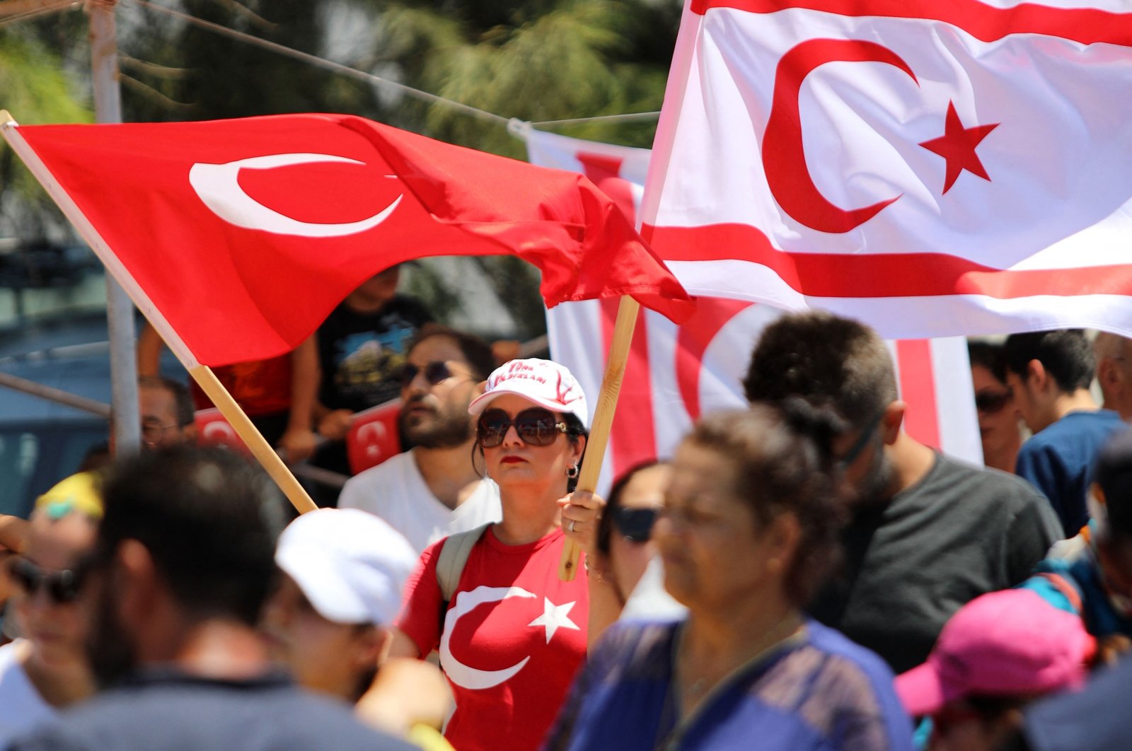 People wave Turkish Cypriot (R) and Turkish flags during a military parade on the anniversary of Türkiye&#039;s Peace Operation, Lefkoşa (Nicosia), Turkish Republic of Northern Cyprus, July 20, 2024. (AFP Photo)