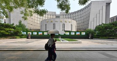 A woman walks past the headquarters of the People’s Bank of China (PBOC), the country’s central bank, Beijing, China, July 9, 2024. (AFP Photo)