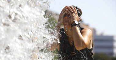 A woman cools off at a fountain during a hot day in Cordoba, southern Spain, July 24, 2024. (EPA Photo)