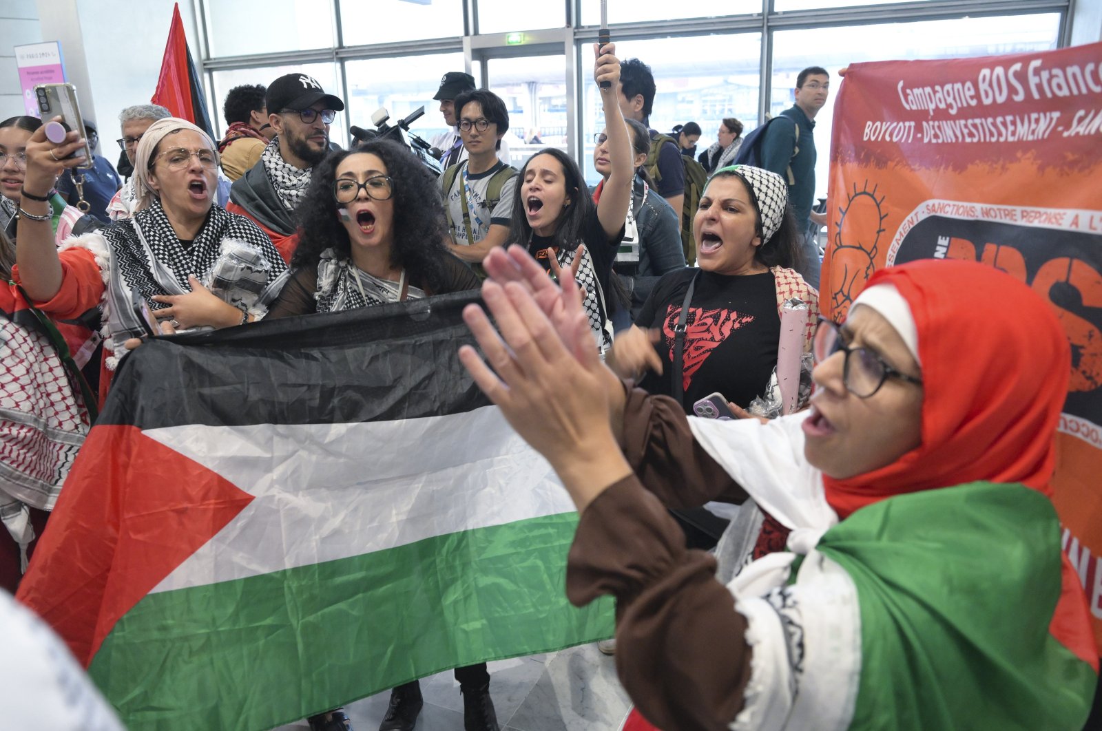 A passionate crowd of Palestinian supporters and members of the national and international press receive Palestinian athletes at the Paris Charles de Gaulle Airport, Paris, France, July 25, 2024. (AA Photo)