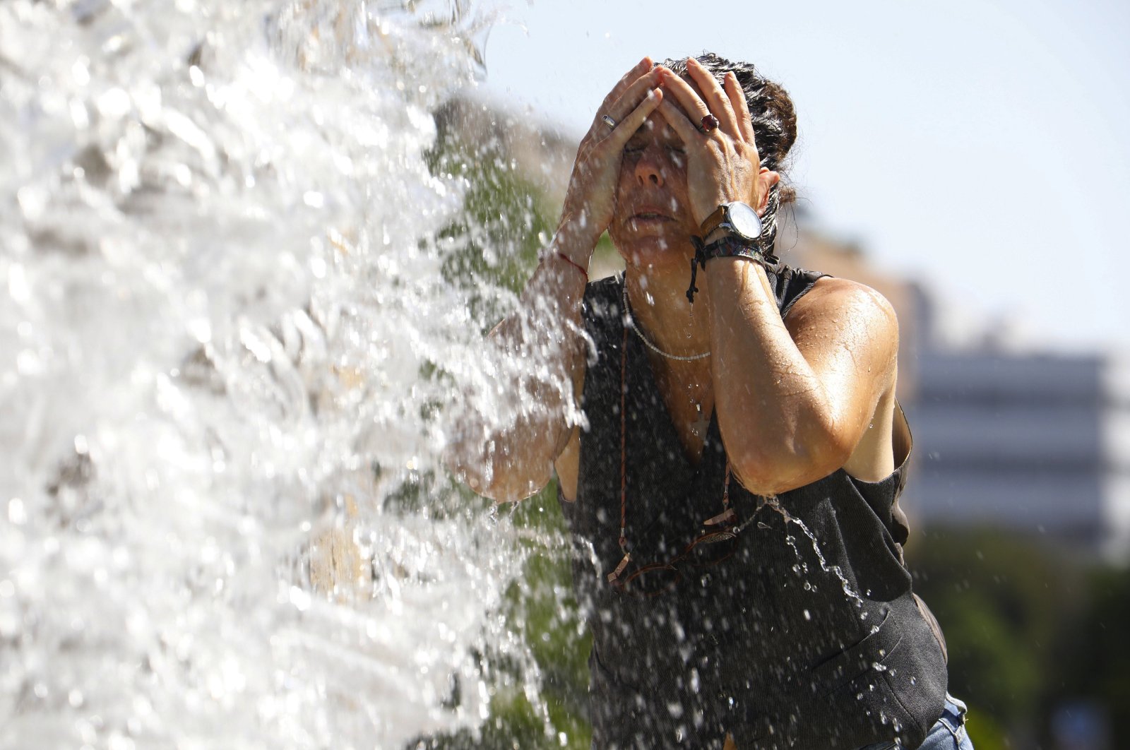 A woman cools off at a fountain during a hot day in Cordoba, southern Spain, July 24, 2024. (EPA Photo)