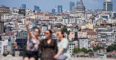 Tourists are seen clicking photos with the backdrop of famed Galata Tower, Istanbul, Türkiye, July 23, 2024. (AA Photo)