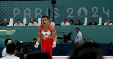 Türkiye's Adem Asil celebrates after his performance on the Parallel Bars at the Paris 2024 Olympics' artistic gymnastics men's qualification subdivision 3 at the Bercy Arena, Paris, France, July 27, 2024. (Reuters Photo)
