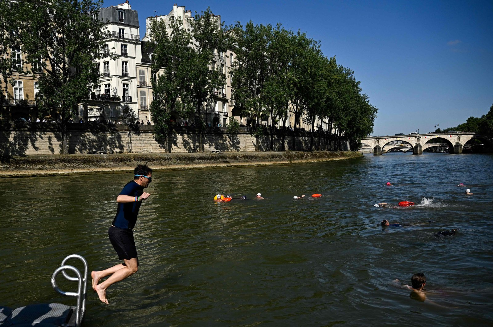 Parisians dive in the Seine after the mayor of Paris swims in the river to demonstrate that it is clean enough to host the outdoor swimming, Paris, France, July 17, 2024. (AFP Photo)