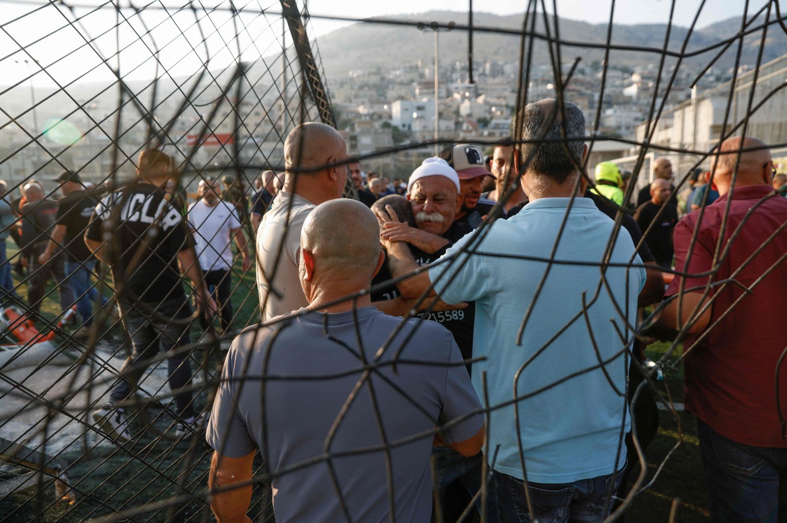 Local residents comfort each other as they gather at a site where a reported strike from Lebanon fell in Majdal Shams village in the Israeli-annexed Golan Heights, July 27, 2024. (AFP Photo)