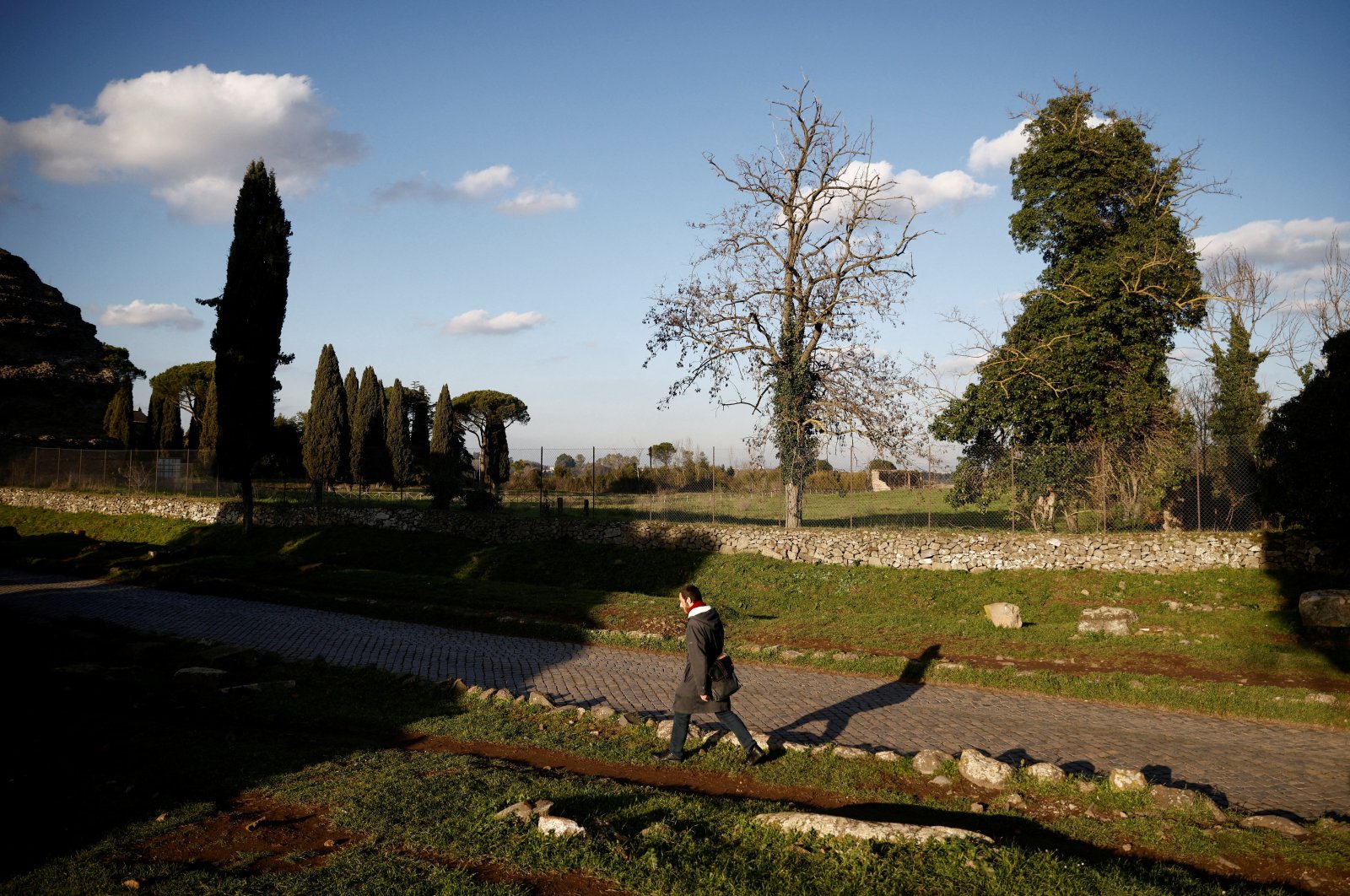 A man walks on the old Appian Way, near the area where a life-sized statue of a Roman emperor posing as the classical hero Hercules was discovered during sewer repair works in Rome, Italy, Feb. 1, 2023. (Reuters Photo)