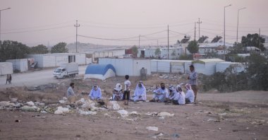 Yazidi men sit together during sunset in the Sharya displacement camp in Duhok, Iraq, June 21, 2024. (AP Photo) 