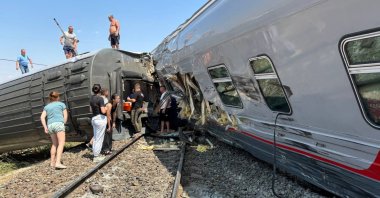 A view shows people near derailed carriages of a passenger train after a collision with a truck in the Volgograd Region, Russia July 29, 2024. (Head of the Kotelnikovsky Municipal District of the Volgograd Region Sergey Ponkratov via Telegram/Handout via Reuters)
