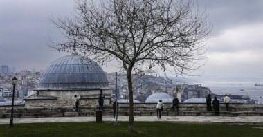 People look at the Bosporus from the Süleymaniye Mosque courtyard, Istanbul, Türkiye, March 15, 2024. (AP Photo)