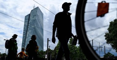 People cross a street in front of the headquarters building of the European Central Bank (ECB), Frankfurt am Main, western Germany, June 5, 2024. (AFP Photo)