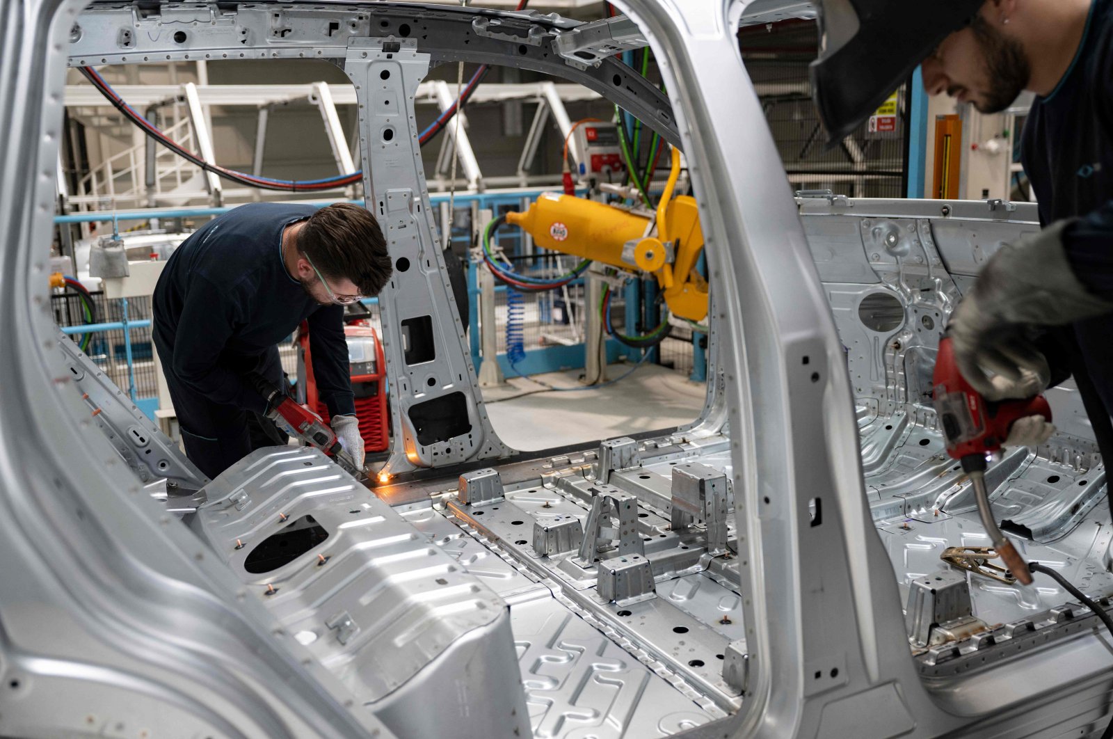 This photograph shows employees working on a car assembly line at a factory of Togg at the Gemlik Togg Technology Campus, Bursa, northwestern Türkiye, May 17, 2024. (AFP Photo)