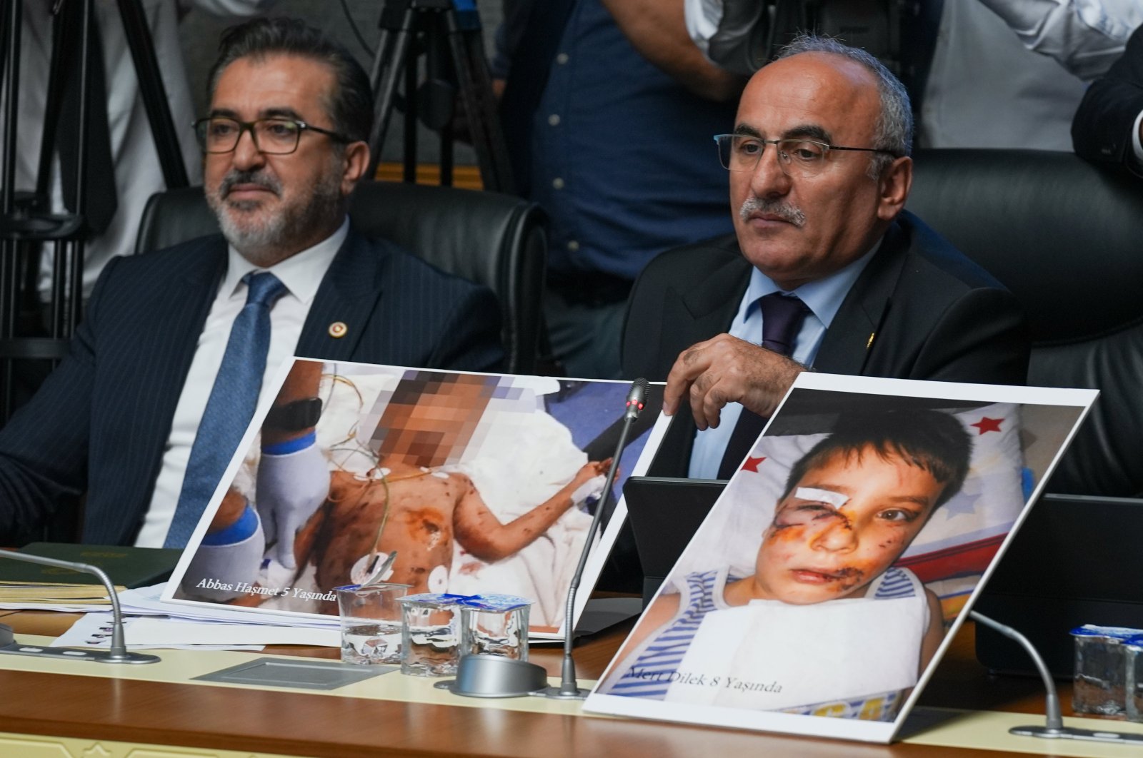 Two lawmakers of the ruling Justice and Development Party (AK Party) show pictures of children killed in stray dog attacks during parliamentary talks on the draft law, the capital Ankara, Türkiye, July 17, 2024. (AA Photo)