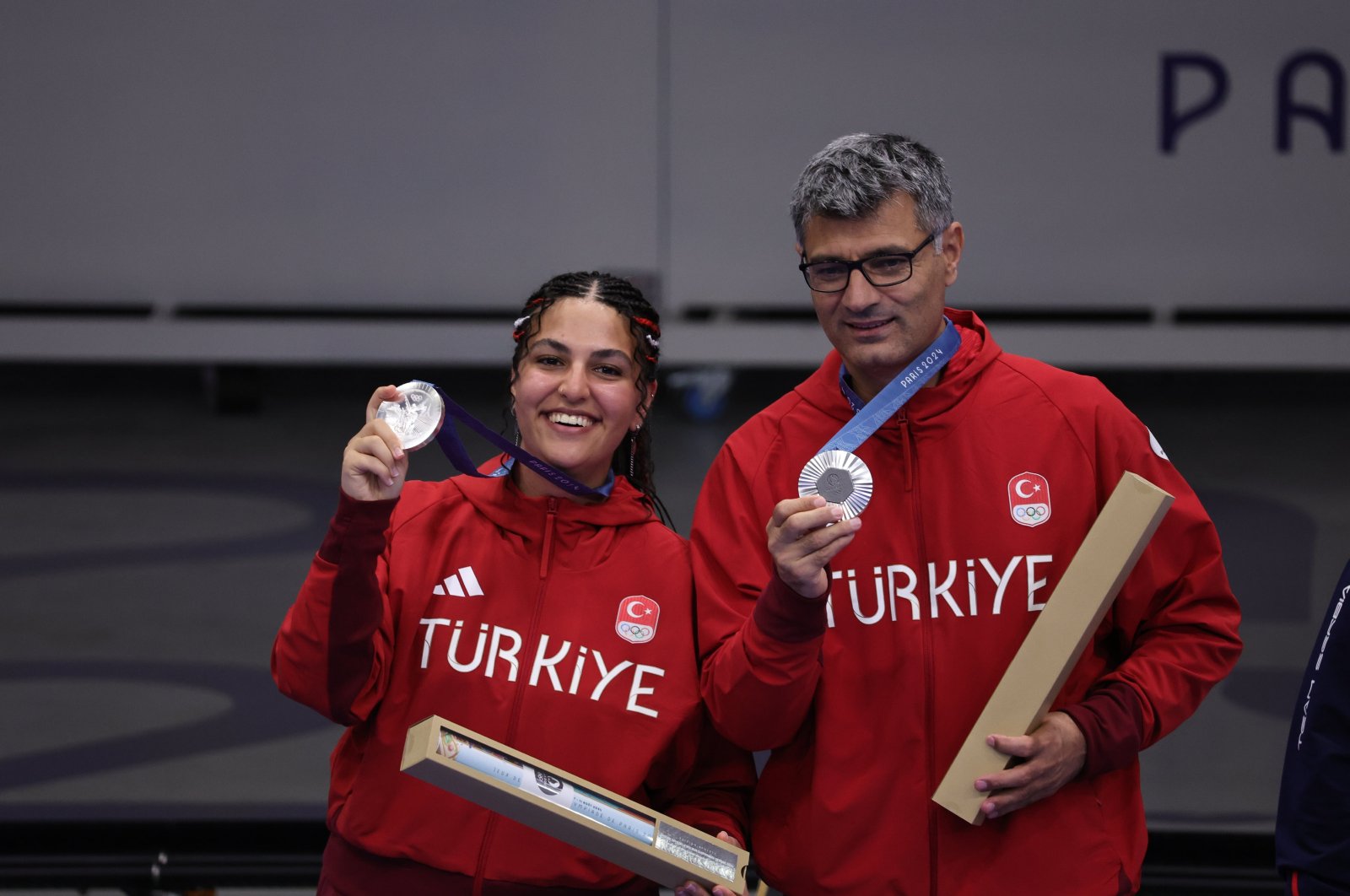 Turkish shooters Şevval Ilayda Tarhan and Yusuf Dikeç show off their 10-meter air pistol event silver medals at the 2024 Paris Olympics, Paris, France, July 30, 2024. (AA Photo)