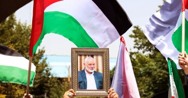 People hold up the Palestinian flag and a portrait of assassinated Hamas chief Ismail Haniyeh Hamas during a rally at Tehran University, in the Iranian capital Tehran, Iran, July 31, 2024. (AFP Photo)