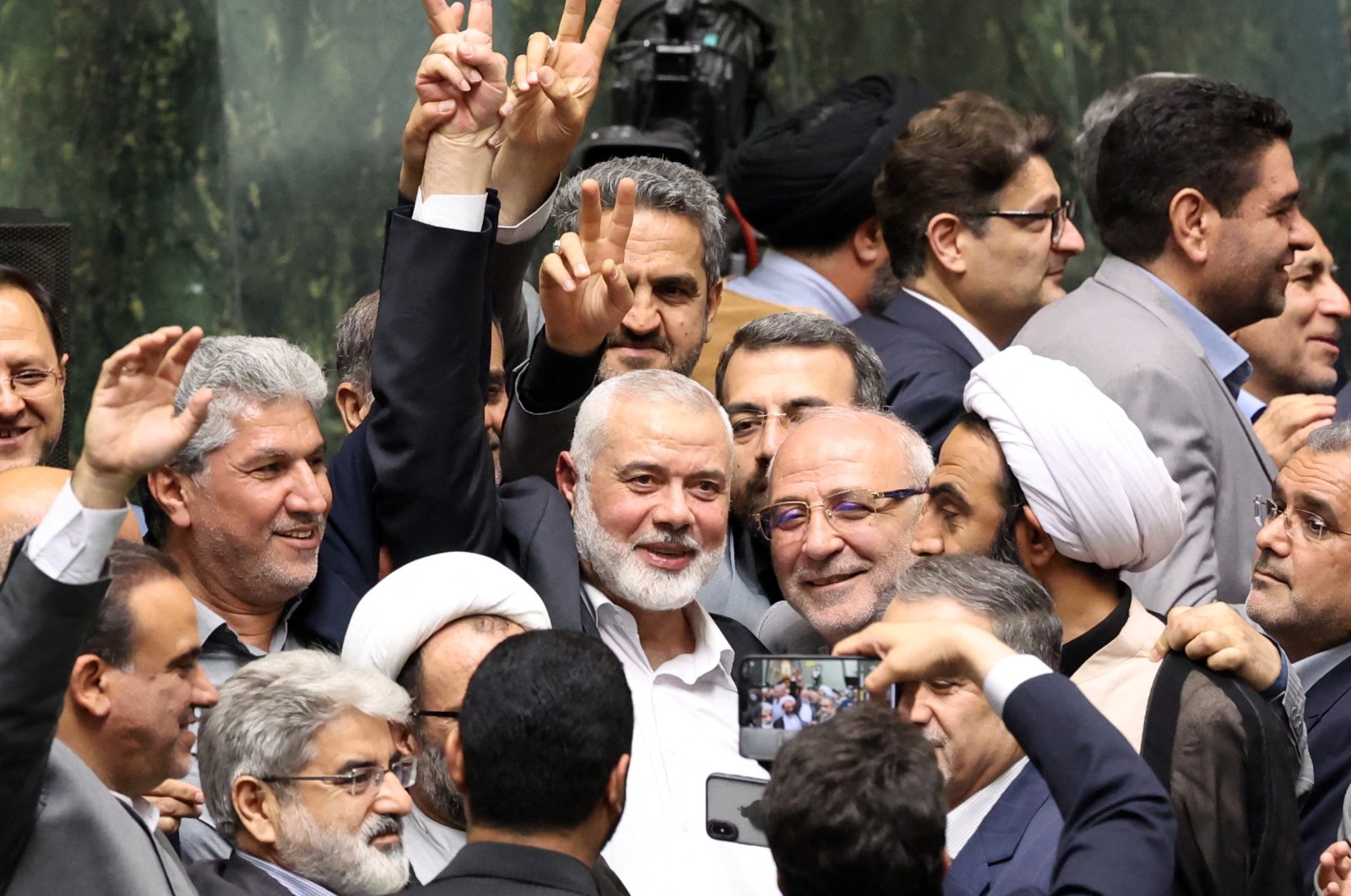 Ismael Haniyeh, Palestinian leader of the militant group Hamas, surrounded by lawmakers flashes the victory sign during the swearing-in ceremony for the new Iranian President, at the parliament in Tehran, Iran, July 30, 2024. (AFP Photo)