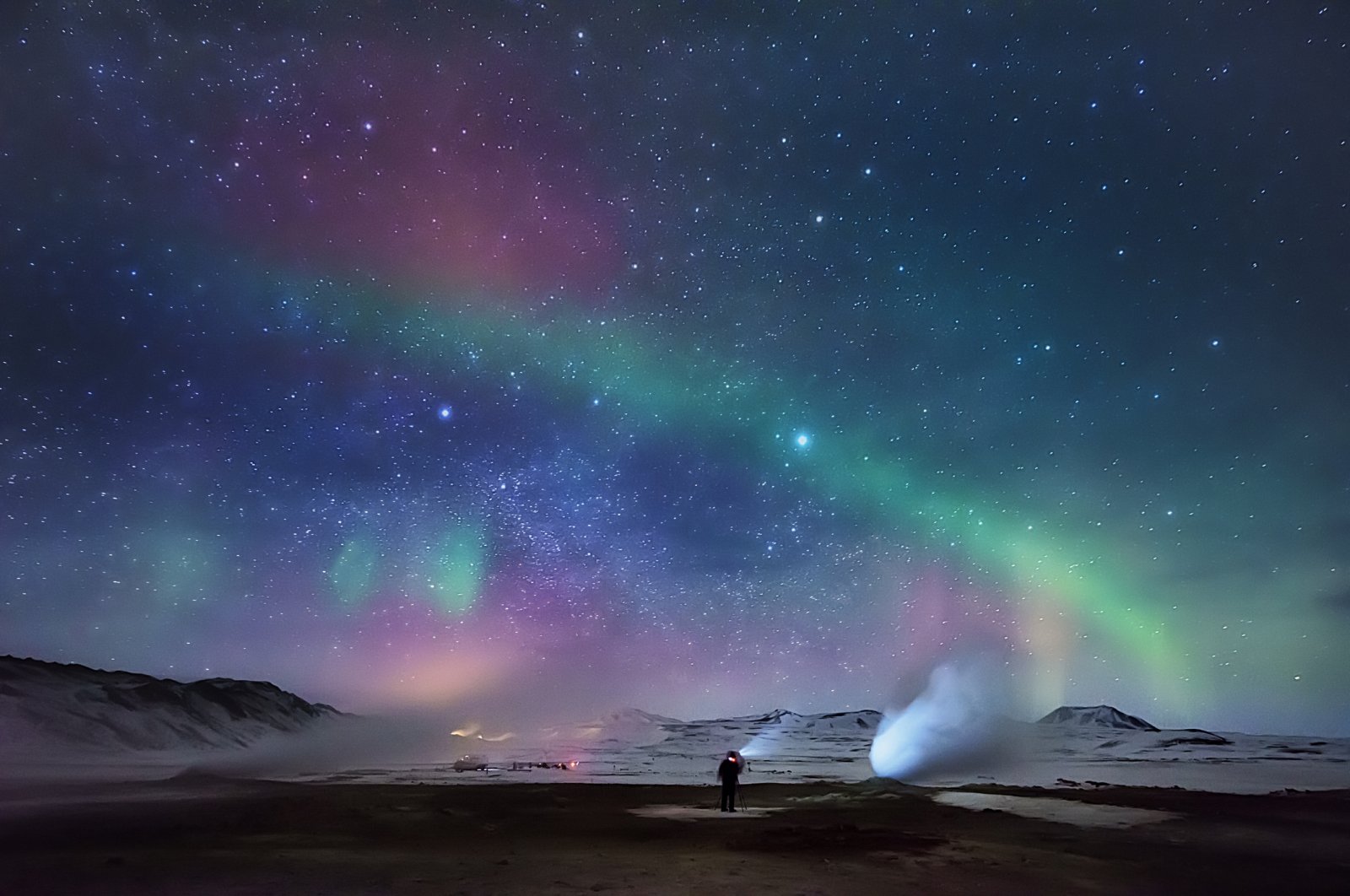 A person enjoys the northern lights over a geothermal hot spring area, Hverarond, Iceland, March 11, 2015. (Getty Images)