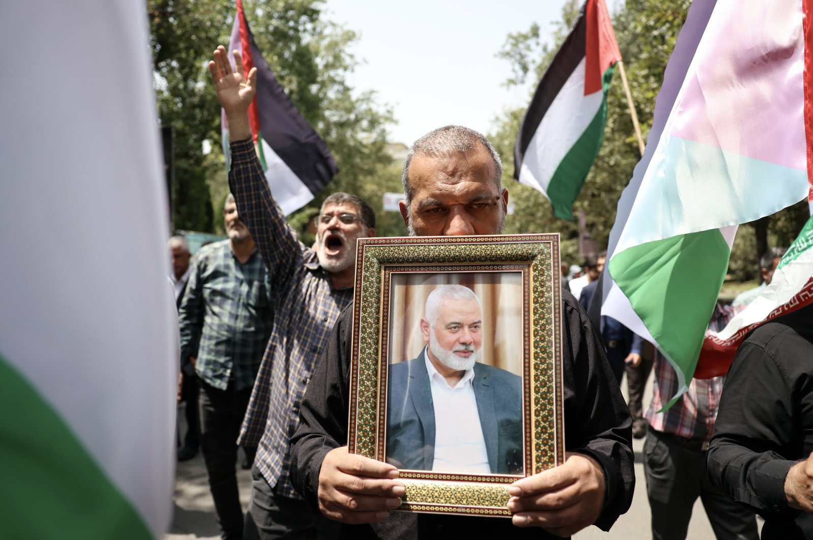 Iranians carry the portrait of late Hamas political leader Ismail Haniyeh and wave Palestinian flags during a protest at Tehran University in Tehran, Iran, July, 31, 2024. (EPA Photo)