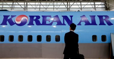 A man walks next to the logo of Korean Air airlines, Seoul, South Korea, June 27, 2024. (Reuters Photo)
