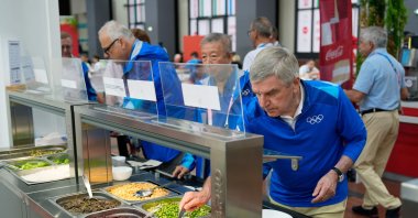 International Olympic Committee (IOC) President Thomas Bach tries food from a salad bar while touring at the Olympic Village ahead of the 2024 Paris 2024 Olympic Games, Saint-Denis, Paris, France, July 22, 2024, (AFP Photo)