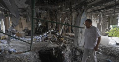 Alya Gali, a Gaza Strip-born doctor, looks at debris two weeks after a missile killed nine as it hit a private clinic where he has worked for most of his professional life, Kyiv, Ukraine, July 22, 2024. (AP Photo)