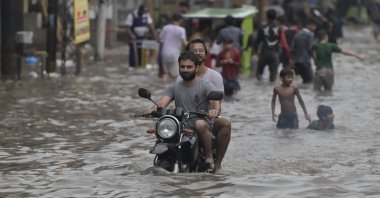 People make their way through a flooded street after heavy rainfall, Lahore, Pakistan, July 28, 2024. (EPA Photo)