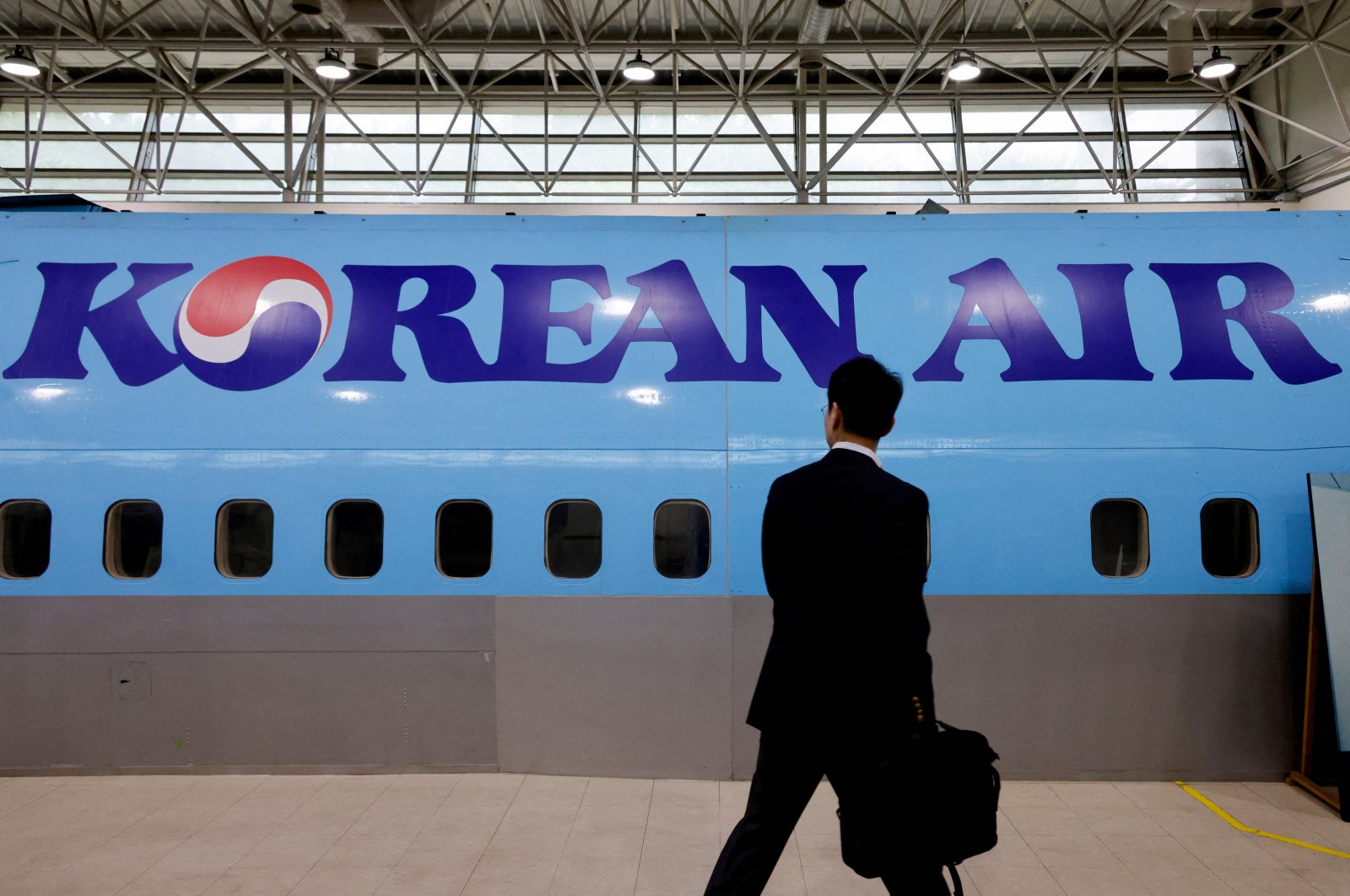 A man walks next to the logo of Korean Air airlines, Seoul, South Korea, June 27, 2024. (Reuters Photo)