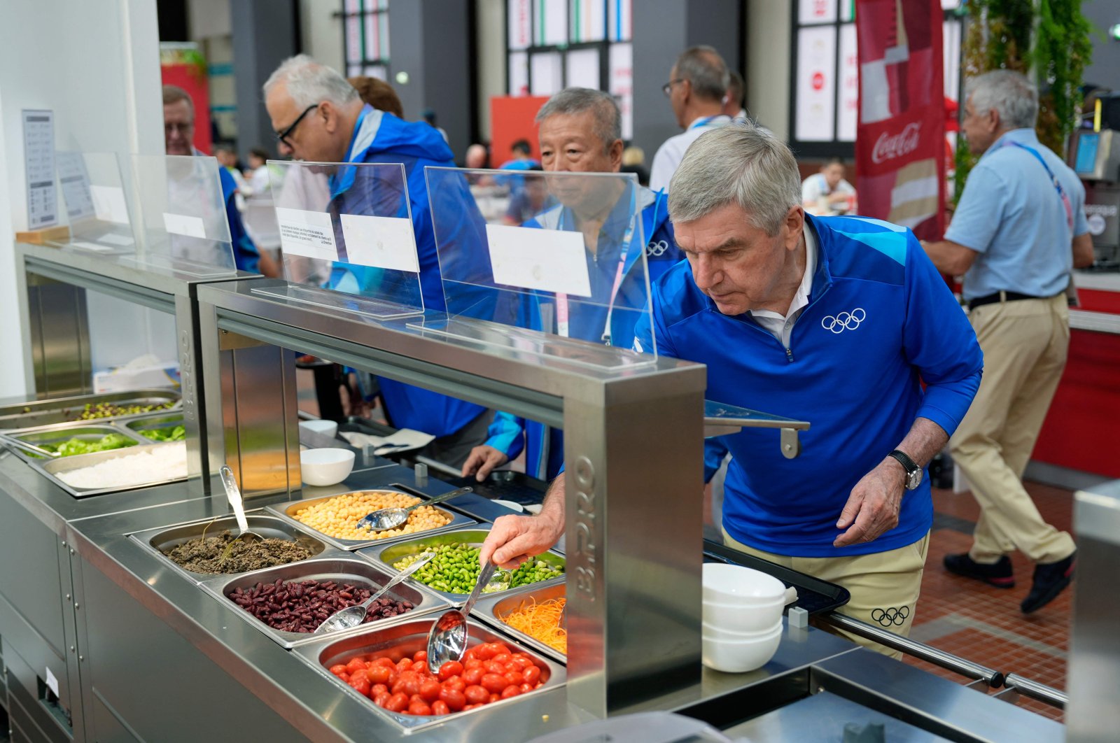 International Olympic Committee (IOC) President Thomas Bach tries food from a salad bar while touring at the Olympic Village ahead of the 2024 Paris 2024 Olympic Games, Saint-Denis, Paris, France, July 22, 2024, (AFP Photo)