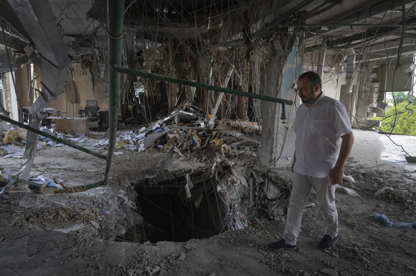 Alya Gali, a Gaza Strip-born doctor, looks at debris two weeks after a missile killed nine as it hit a private clinic where he has worked for most of his professional life, Kyiv, Ukraine, July 22, 2024. (AP Photo)