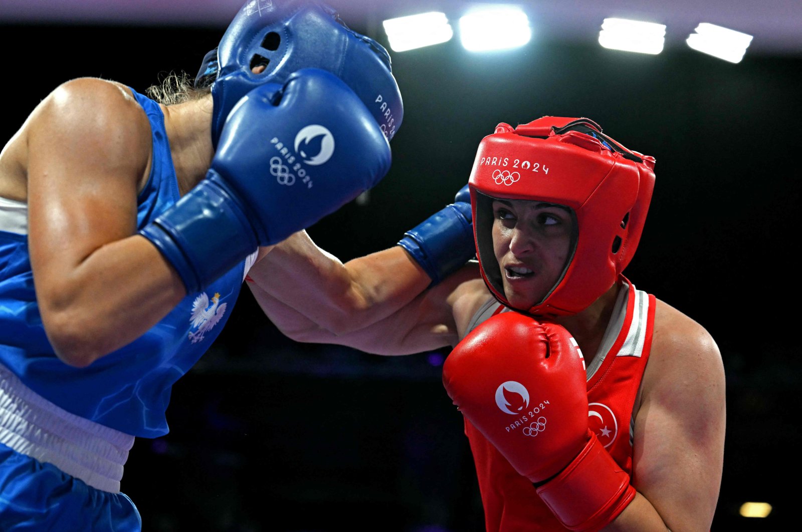 Poland&#039;s Aneta Rygielska (L) takes a punch from Türkiye&#039;s Busenaz Sürmeneli in the women&#039;s 66 kg. preliminaries round of 16 boxing match during the Paris 2024 Olympic Games at the North Paris Arena, Villepinte, France, Aug. 1, 2024. (AFP Photo)