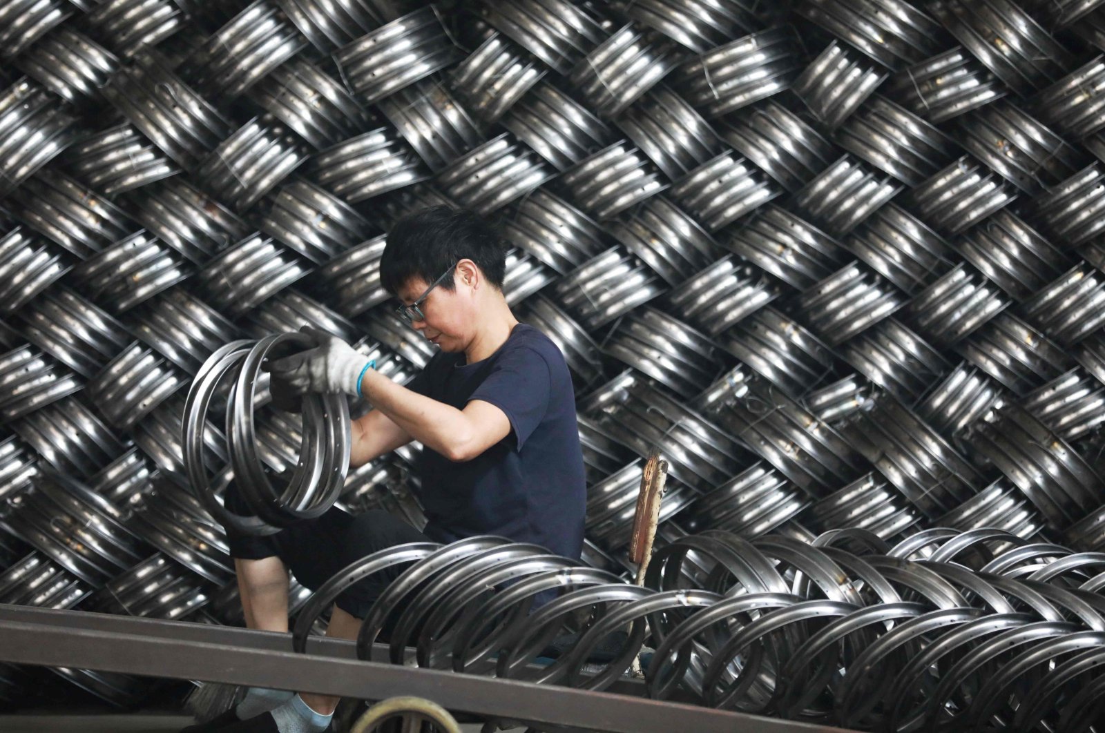 A worker sorts wheels at a factory that produces bicycle parts for export in Hangzhou, eastern Zhejiang province, China, July 15, 2024. (AFP Photo)