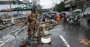 Motorists drive past a tree trunk washed along a street at the height of flooding amid heavy rains brought about by Typhoon Gaemi, Manila, Philippines, July 25, 2024. (AFP Photo)