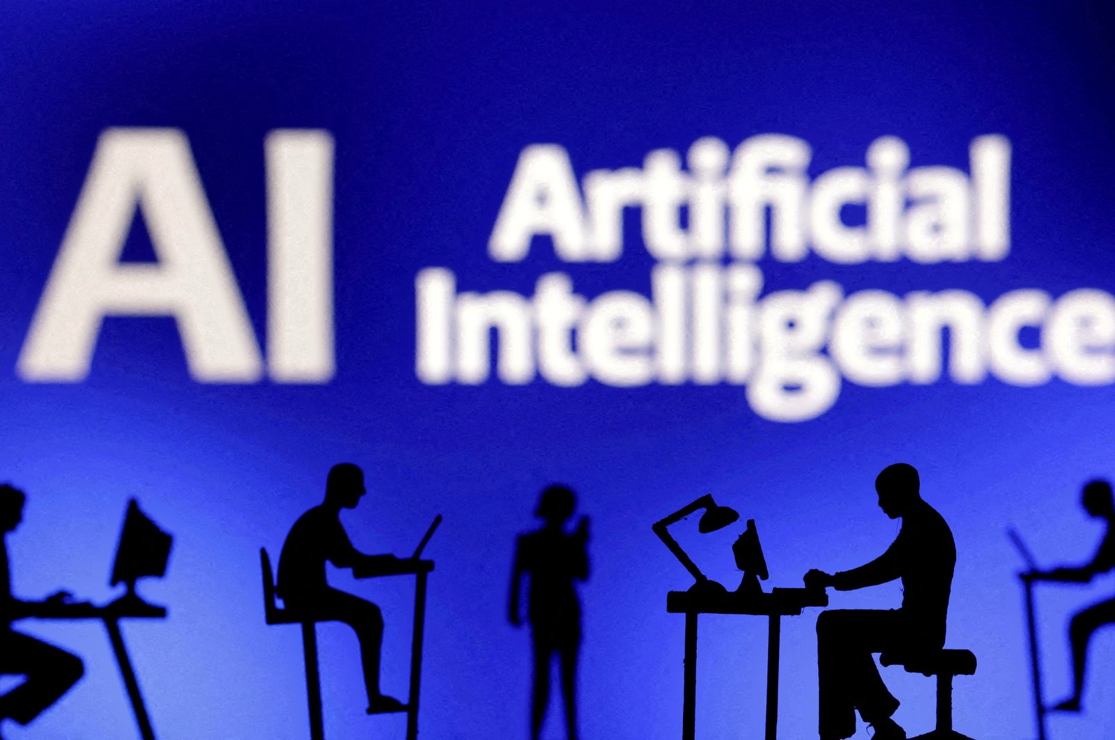 Figurines with computers and smartphones are seen in front of the words &quot;Artificial Intelligence AI&quot; in this illustration taken Feb. 19, 2024. (Reuters Photo)