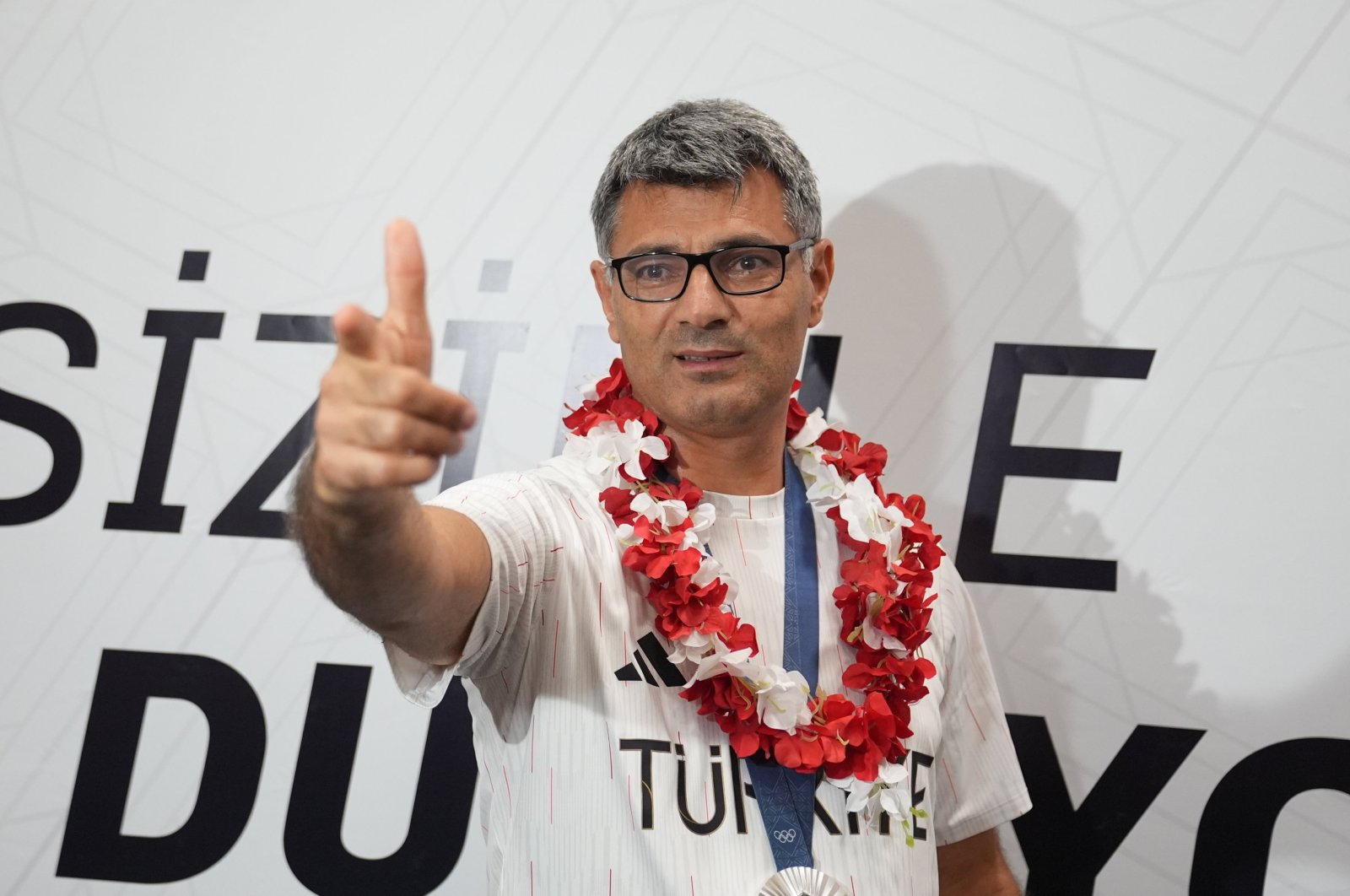 Turkish shooter Yusuf Dikeç poses for a photo on his arrival at the Esenboğa Airport, Ankara, Türkiye, Aug. 1, 2024. (AA Photo)