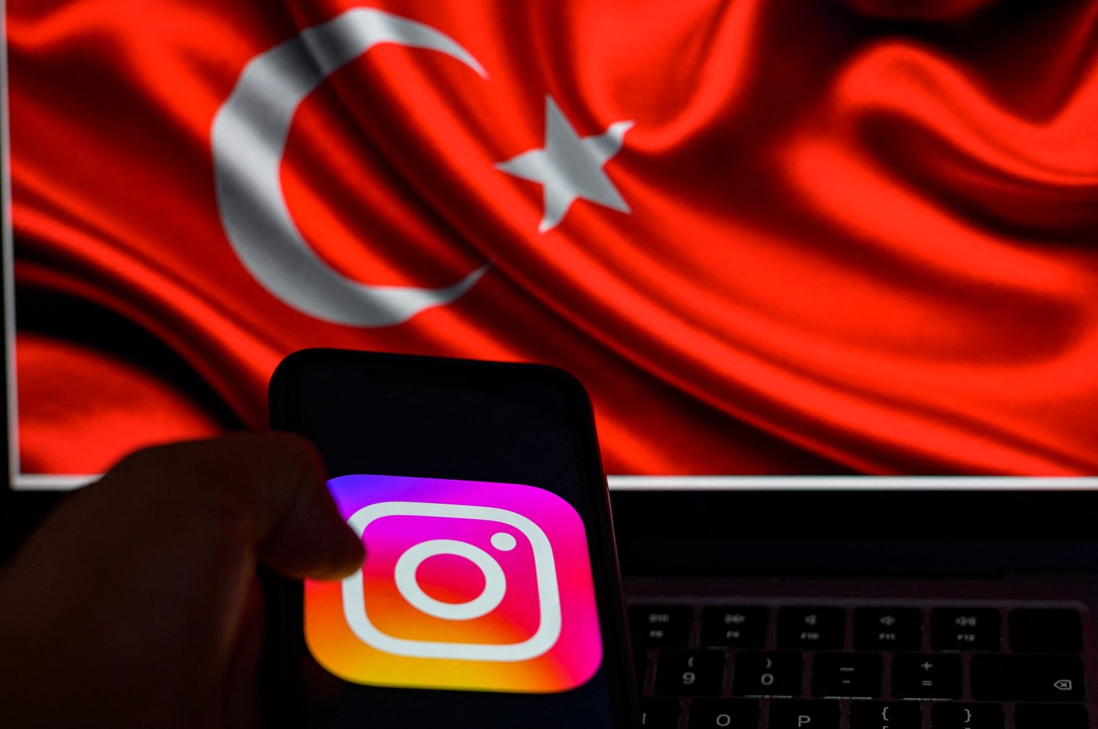 This picture taken in Istanbul shows the logo of the social network Instagram on a smartphone with the Turkish flag in the background, Türkiye, Aug. 2, 2024. (AFP Photo)