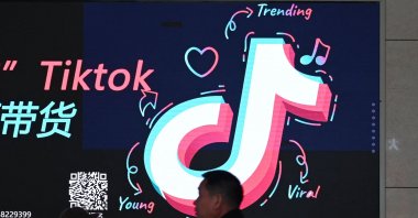 People walk past an advertisement featuring the TikTok logo at a train station in Zhengzhou, in China’s central Henan province, Jan. 21, 2024. (AFP Photo)