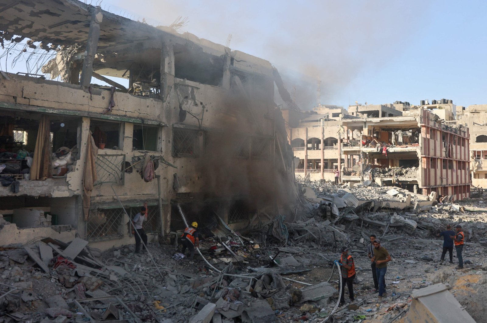 Palestinian rescuers extinguish a fire at a destroyed building following Israeli bombardment which hit a school complex, in the Sheikh Radwan neighborhood, north of Gaza City, Palestine, Aug. 3, 2024. (AFP Photo)