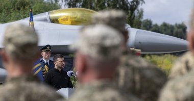 Ukrainian President Volodymyr Zelenskyy speaks to servicemen next to an American single-engine supersonic multirole F-16 fighter jet at an undisclosed location in Ukraine, Aug. 04, 2024. (EPA Photo)