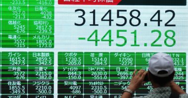 A pedestrian takes a photo of a display showing the closing information of the Nikkei Stock Average, Tokyo, Japan, Aug. 5, 2024. (EPA Photo)