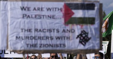 Demonstrators shout slogans, as they hold Palestine flags and placards condemning Israel's attacks on Gaza, Limassol, Greek Cypriot administration, Jan. 14, 2024. (AP Photo)