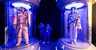 People use their mobile phones next to showcases with space suites during the forum of innovations Moscow-2030, Moscow, Russia, Aug. 1, 2024. (Reuters Photo)