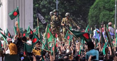 Anti-government protestors march toward Prime Minister Sheikh Hasina&#039;s official residence as army personnel (C) stand guard in Dhaka, Bangladesh, Aug. 5, 2024. (AFP Photo)