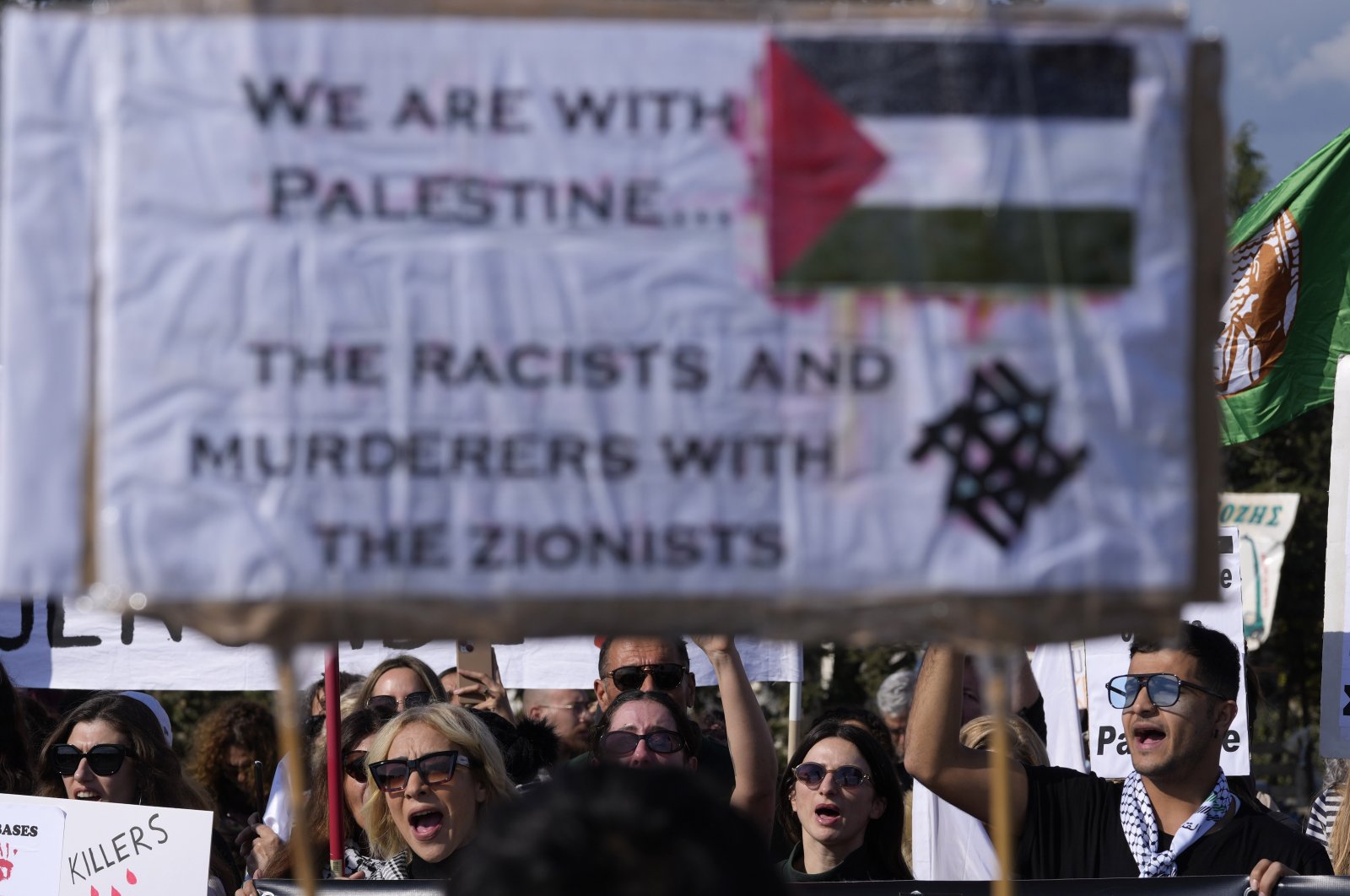 Demonstrators shout slogans, as they hold Palestine flags and placards condemning Israel&#039;s attacks on Gaza, Limassol, Greek Cypriot administration, Jan. 14, 2024. (AP Photo)