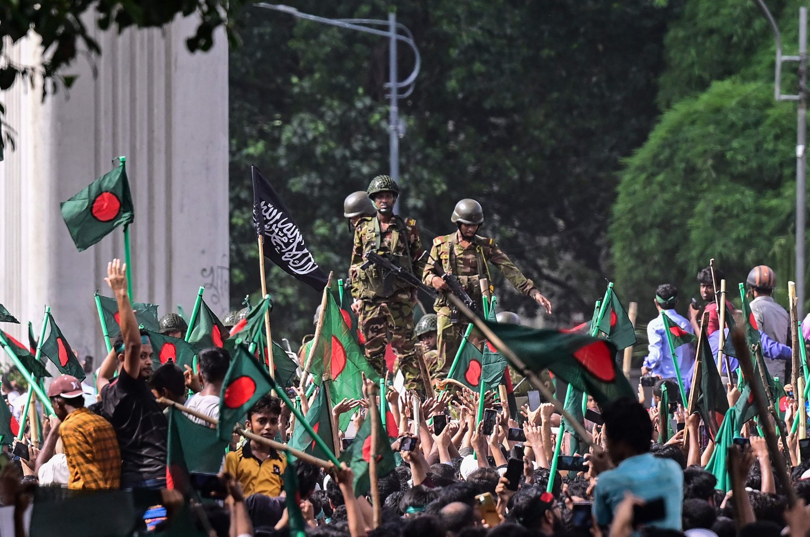 Anti-government protestors march toward Prime Minister Sheikh Hasina&#039;s official residence as army personnel (C) stand guard in Dhaka, Bangladesh, Aug. 5, 2024. (AFP Photo)