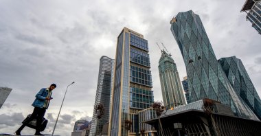 A pedestrian passes skyscraper office buildings close to the Istanbul Financial Center (IFC), Istanbul, Türkiye, May 9, 2023. (Getty Images Photo)