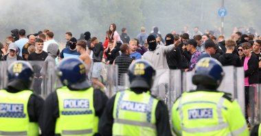 Police officers stand opposite to demonstrators during an anti-immigration, anti-Muslim protest, Rotherham, Britain, Aug 4, 2024. (Reuters Photo)