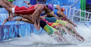 Athletes jump into the water to compete in the swimming race in the Seine, during the mixed relay triathlon, at the Paris 2024 Olympic Games, Paris, France, Aug. 5, 2024. (AFP Photo)