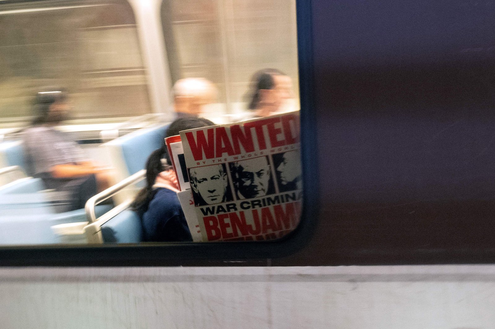 A pro-Palestinian protester holds a sign inside a bus during a demonstration outside the Watergate Hotel following Israeli Prime Minister Benjamin Netanyahu’s address at Congress, Washington, D.C., U.S., July 24, 2024. (AFP Photo)